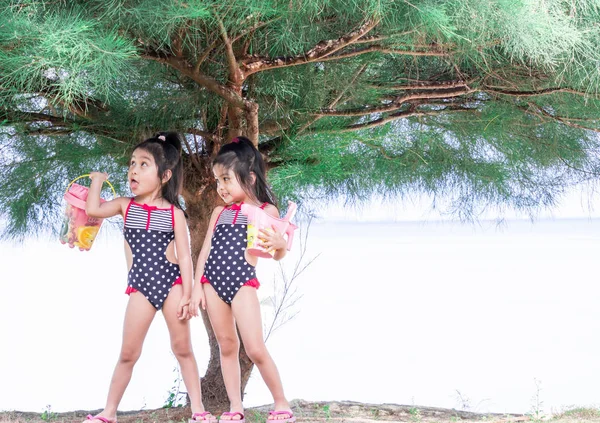 Милые азиатские близнецы-малыши, играющие под деревом — стоковое фото