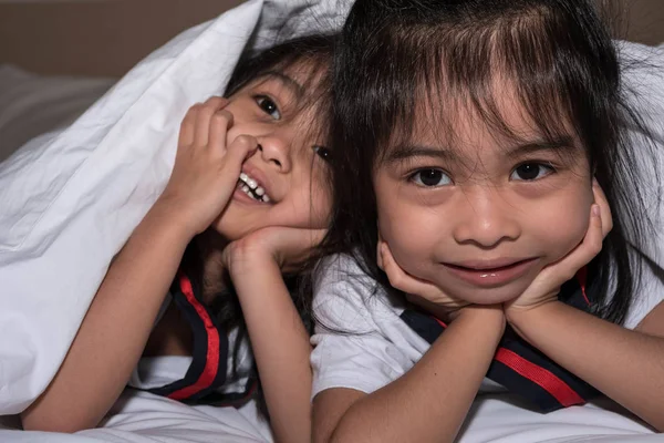 Felice bambine gemelle sorella a letto sotto la coperta avendo — Foto Stock