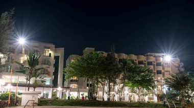 Parlak ışıklar ve ağaç ile gece boyunca bir plaj tesisi Otel