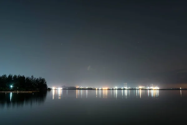 Vista costeira do mar, cais, céu durante o anoitecer com luzes refletem — Fotografia de Stock