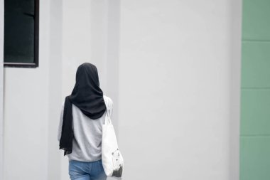 Kadın müslüman kız geri görünümü yürüyüş. Kadın müslüman siyah hijab 