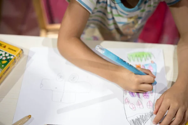 Criança escrevendo desenho colorir no papel usando lápis de cor — Fotografia de Stock