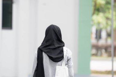 Kadın müslüman kız geri görünümü yürüyüş. Kadın müslüman siyah hijab 