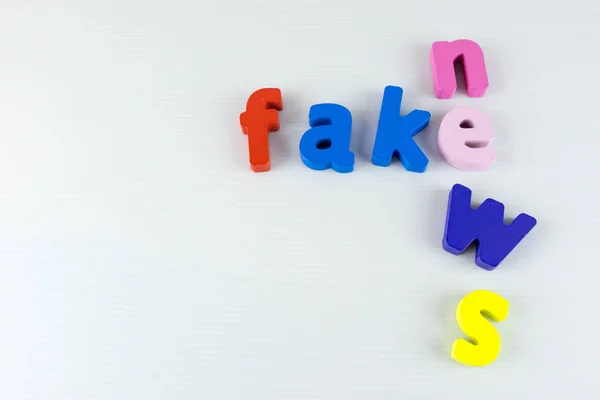 Cartas coloridas de notícias falsas com fundo branco — Fotografia de Stock