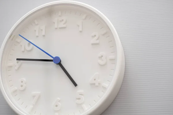 Clock face showing five o'clock with white background. White rou