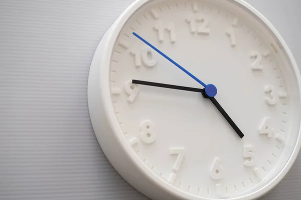 Clock face showing five o'clock with white background. White rou