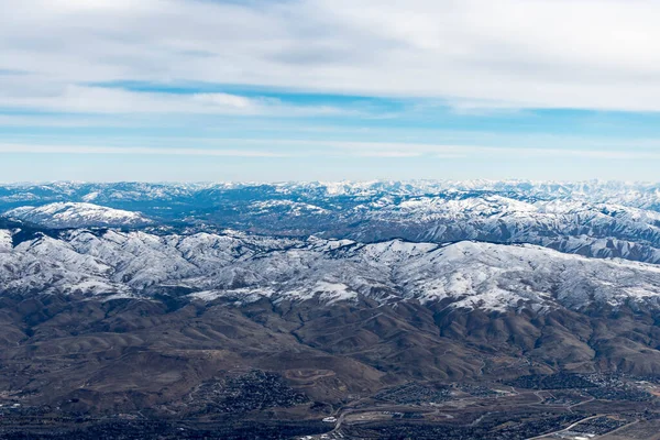 飛行機の中にいる間 アイダホ州の山々の空中ビュー 雪に覆われた茶色の山や木々の景色 — ストック写真