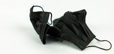 Beyaz zemine atılmış cerrahi maske kullanılmış. Covid 19 'un korunması için kullanılan maske düzgün yerleştirilmemiş ve her yere atılmış.