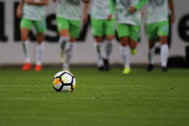 Wolfsburg, Almanya 11 Ekim 2017. Bir futbol topu futbol sahası ile uzaktan maç sırasında Vfl Wolfsburg ve Atletico Madrid Aok Stadion Wolfsburg çalışan bazı futbolcular çimenlerin üzerinde. 