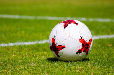 beyaz ve kırmızı futbol topu futbol sahası çimenlerin üzerinde.