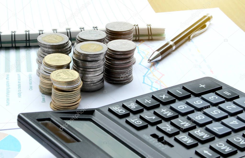 Calculator and Coins of thailand on the office desk investment and property for concept.