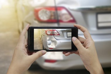 El bir araba kazası, kaza sigortası için yerinde bir fotoğraf akıllı telefon almak tutarak.