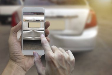 El bir araba kazası, kaza sigortası için yerinde bir fotoğraf akıllı telefon almak tutarak.