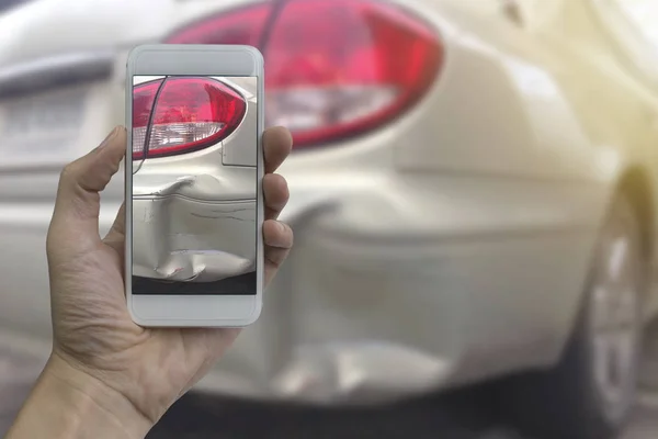 El bir araba kazası, kaza sigortası için yerinde bir fotoğraf akıllı telefon almak tutarak.