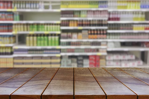 空の木製テーブル空間プラットフォームと製品表示モンタージュの製品棚背景にぼやけスーパー通路 — ストック写真