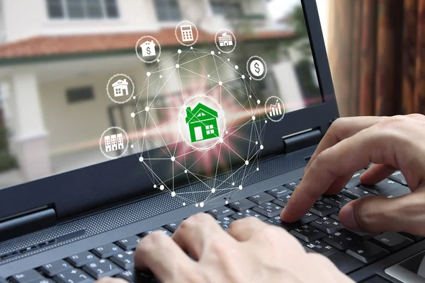 Hand use laptop computer with property investment icons over the Network connection on property background, Property investment concept.