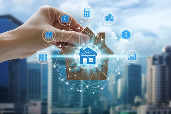 Hand holding with property investment icons over the Network connection on property background, Property investment concept