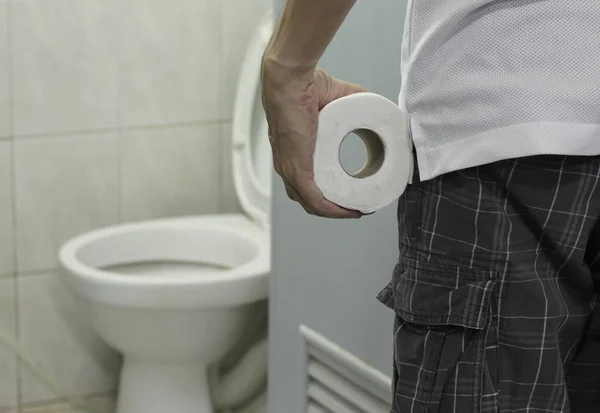 Hand houden toiletpapier roll en het invoeren van het toilet. — Stockfoto