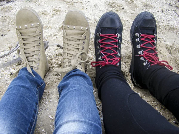 Pernas femininas namoradas na praia em sapatos . — Fotografia de Stock