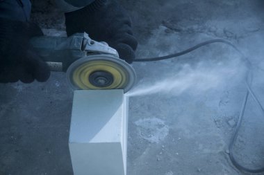 Binaların onarımı ve inşası. Dairesel taşlama makinesinin diskbeyaz tuğla keser döner.