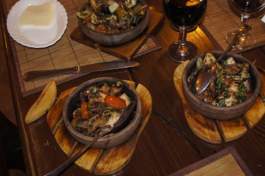 Ahşap bir stand üzerinde koyu bir tavada kızarmış et ve mumlar.