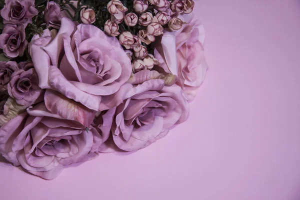Romántico ramo de flores pastel. Rosas lila sobre fondo rosa . — Foto de Stock