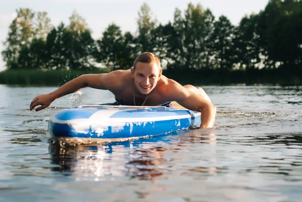 Een schattige jonge kerel houdt zich bezig met Sap surfen — Stockfoto