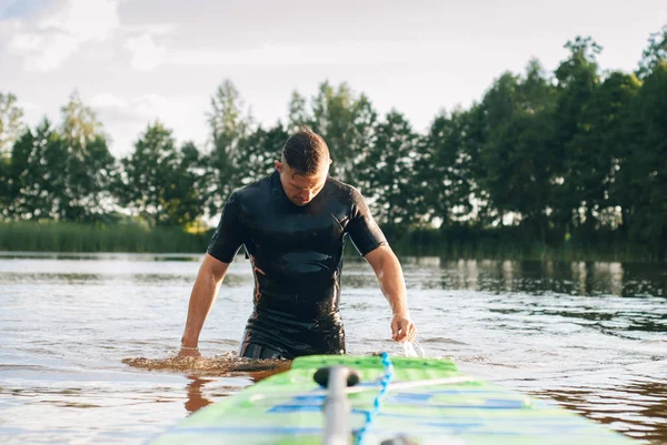 Bir erkekte bir wetsuit denizden ortaya çıkıyor.,