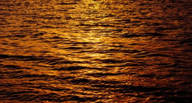 Güneş deniz, sıvı altın dalgalar halinde yansıtılır