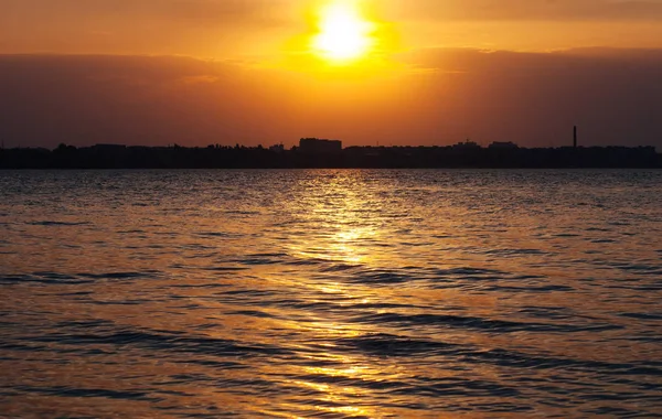 Sunset on the water, the sun sets over the horizon and reflected in the waters of the Dnieper