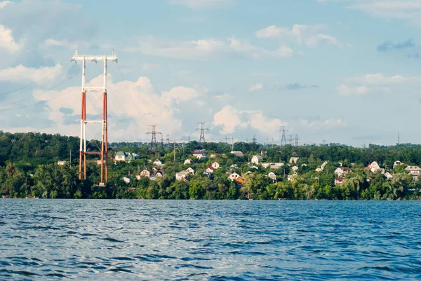 Power line rozciąga się nad rzeką, linie energetyczne na wsi, — Zdjęcie stockowe