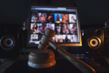 Bilgisayar ekran, yasadışı site yetişkin içerikli bilgisayar hoparlörleri ve klavye, Internet alanında bir düşük anahtar fotoğrafçılıkta yasa kırılma kavramı ile masaüstünde arka plan üzerinde çekiç