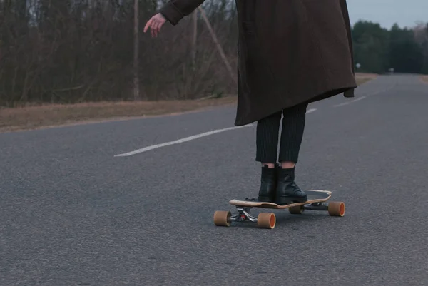 Meisje model skateboarden op een landelijke weg, close-up, — Stockfoto