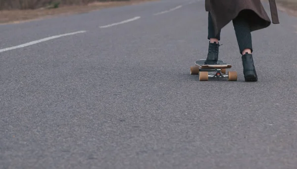 Meisje model skateboarden op een landelijke weg, close-up, — Stockfoto