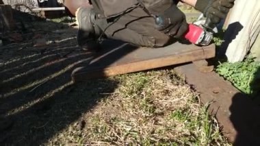 Eldiven giyen işçiler zımpara ile metal plakayı ikiye bölüyor, ev işi.,