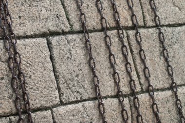 Taş duvara karşı paslı zincir, birkaç uzun paslı zincir,