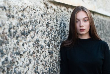 Siyah balıkçı yaka kazak güzel genç kız beton duvara poz