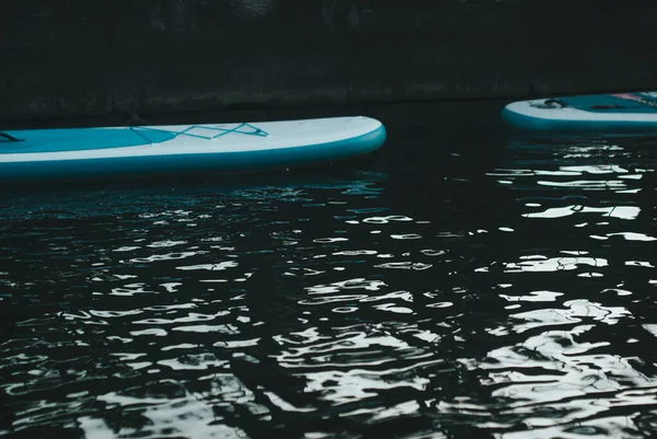 Paddleboard plovoucí na tmavé vodě, dispozice pro reklamu, kopírovací prostor, — Stock fotografie