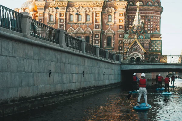 Σηκωθείτε κουπί με τα πόδια κατά μήκος του ποταμού στην Αγία Πετρούπολη φεστιβάλ στην Αγία Πετρούπολη, κωπηλάτης στο φόντο της Εκκλησίας, — Φωτογραφία Αρχείου