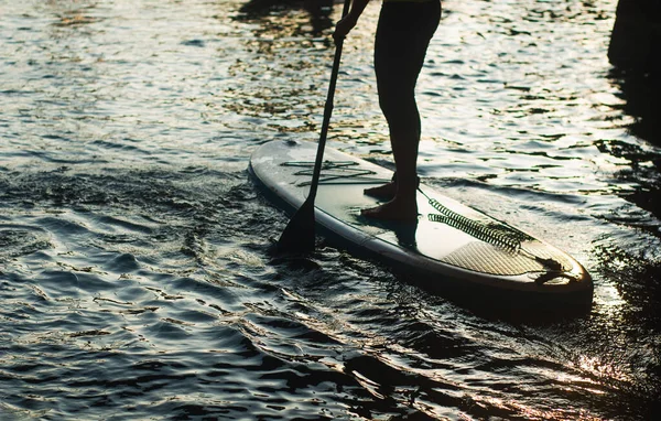Σηκωθείτε κουπί surfing σιλουέτα. ένας άντρας στέκεται με ένα κουπί σε ένα κοντινό πλάνο., — Φωτογραφία Αρχείου