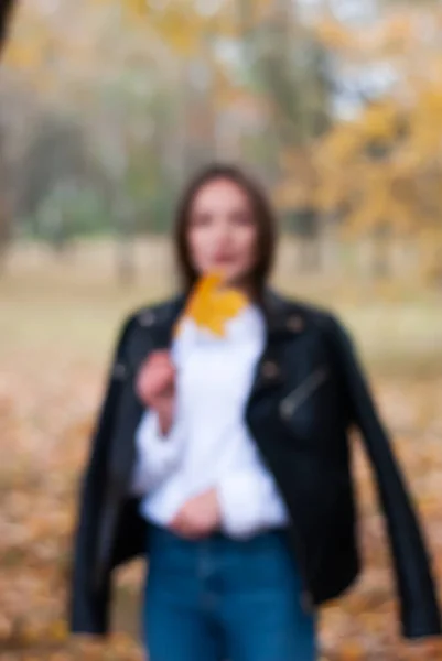 Розмитий знімок молодої дівчини, що йде в осінньому парку , — стокове фото