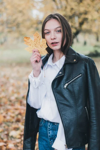 Jovem mulher segurando árvore folha de ouro ao ar livre na floresta , — Fotografia de Stock