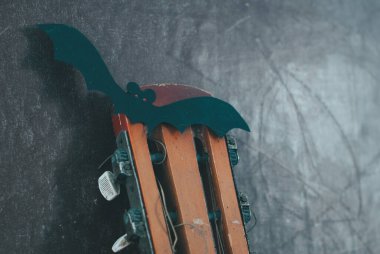 Sonbahar sezonunda akustik gitar. Gitarda çelenk ve sopa var. Cadılar Bayramı ve Kara Cuma 'da gitar satışı kavramı,