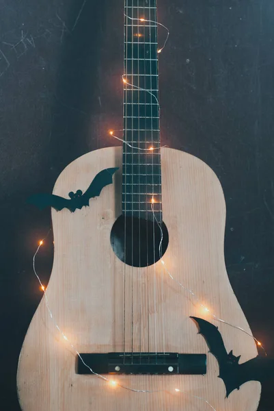 Guitarra acústica en temporada de otoño. guitarra con guirnalda y bate. Concepto de venta de guitarras en Halloween y Viernes Negro , — Foto de Stock