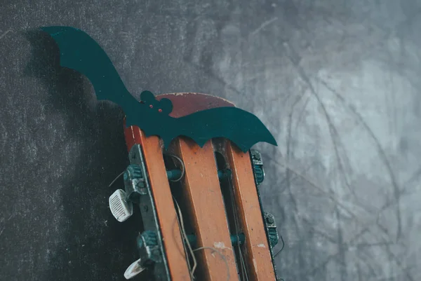 Ακουστική κιθάρα την φθινοπωρινή εποχή. κιθάρα με γιρλάντα και ρόπαλο. Concept πώληση κιθάρας στις Απόκριες και μαύρη Παρασκευή, — Φωτογραφία Αρχείου
