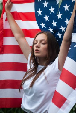 Açık havada Amerikan bayrağı taşıyan kız, mekan bir mısır tarlası.,