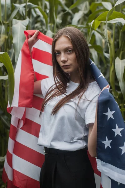 Ta dívka s americkou vlajkou venku, to místo je kukuřičné pole., — Stock fotografie