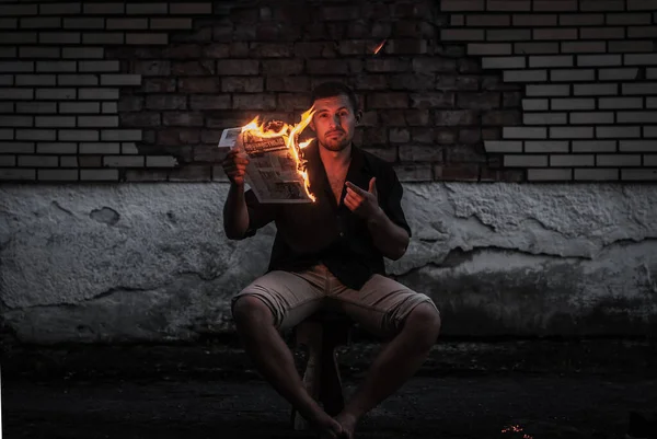 ある男は燃える新聞を読み火を燃やすメディアの概念は — ストック写真