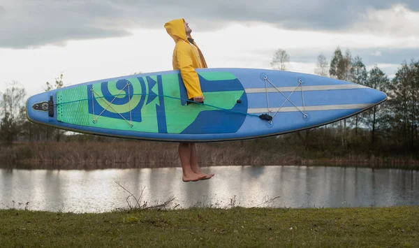 Surfer met een Board bij bewolkt weer, dynamische fotografie, — Stockfoto