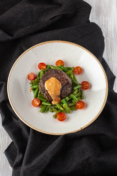 Filé de mignon raro médio assado com feijão verde e tomate cereja fresco, decorado com molho cremoso para um jantar saudável em um restaurante — Fotografia de Stock